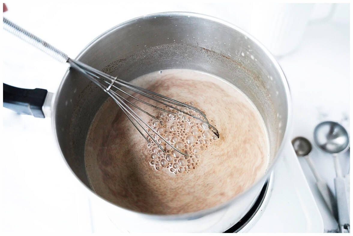 whisk in stainless sauce pan with ingredients to make pumpkin spice, cinnamon and maple syrup