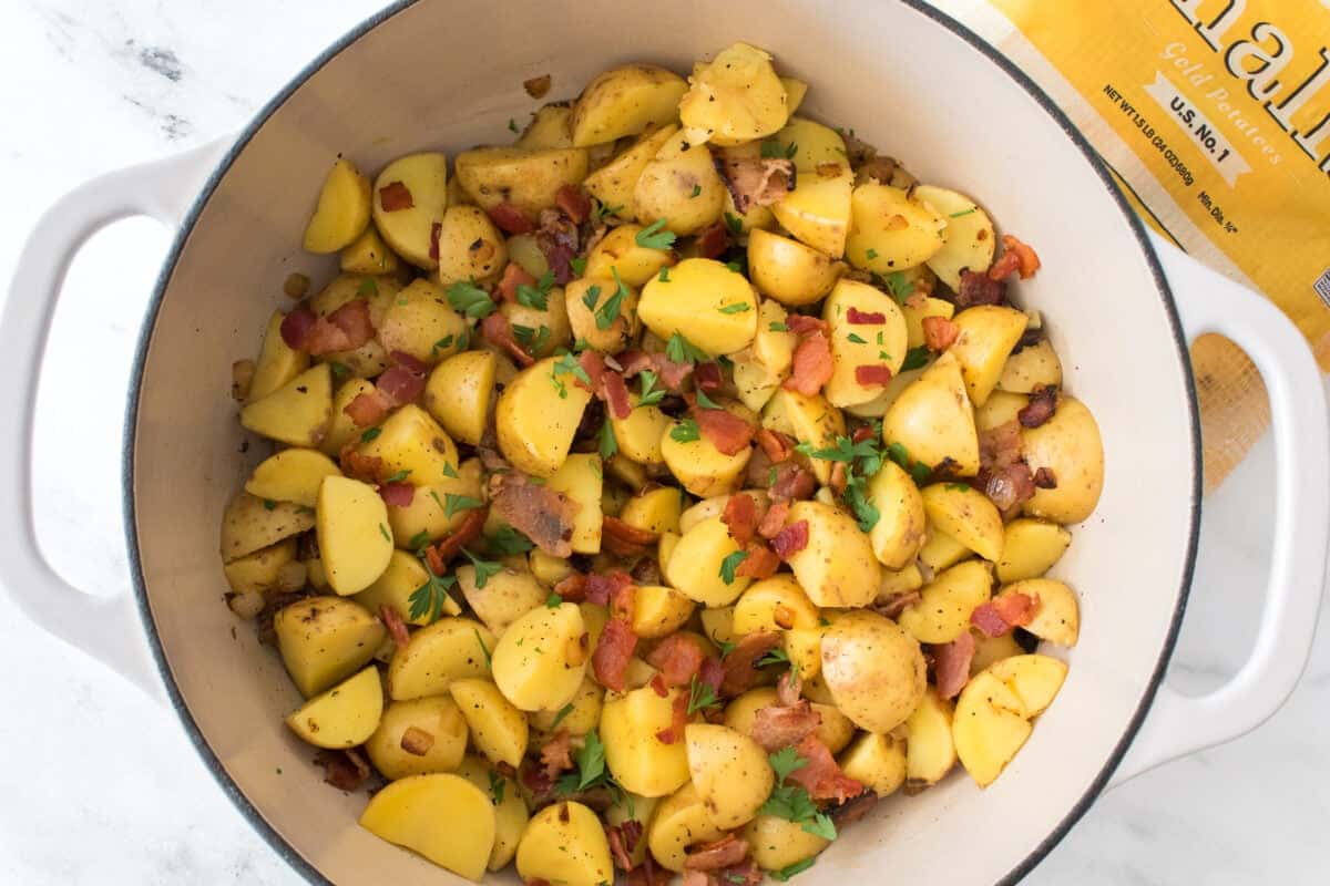 overhead final shot of german potato salad garnished with crisp bacon and freshly chopped parsley