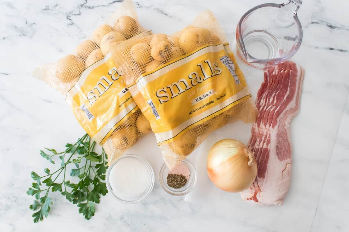 ingredients to make german potato salad: two bags of wada farms smalls gold potatoes, 6 strips of bacon, white vinegar, sugar, salt and pepper, parsley and onion