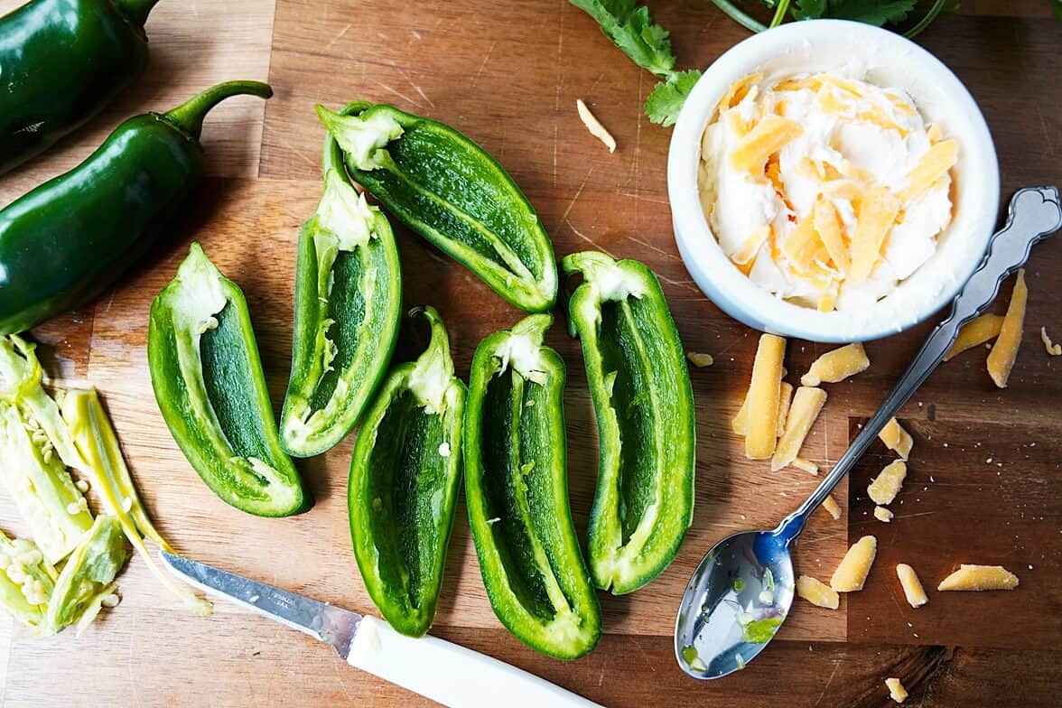 halved jalapenos on a cutting board