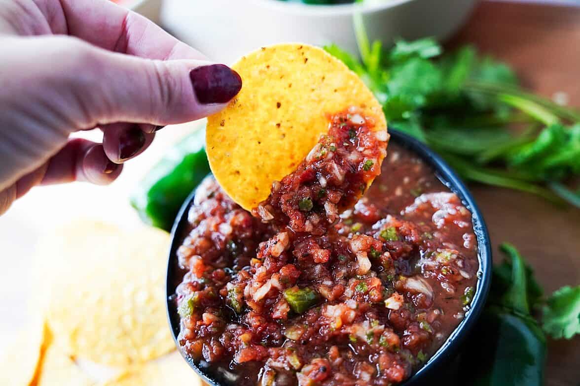 Chip being dipped in salsa