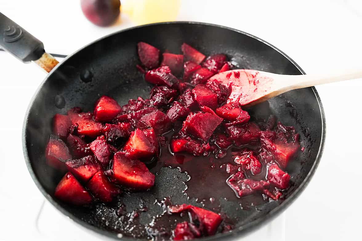 chunks of plums in skillet with water