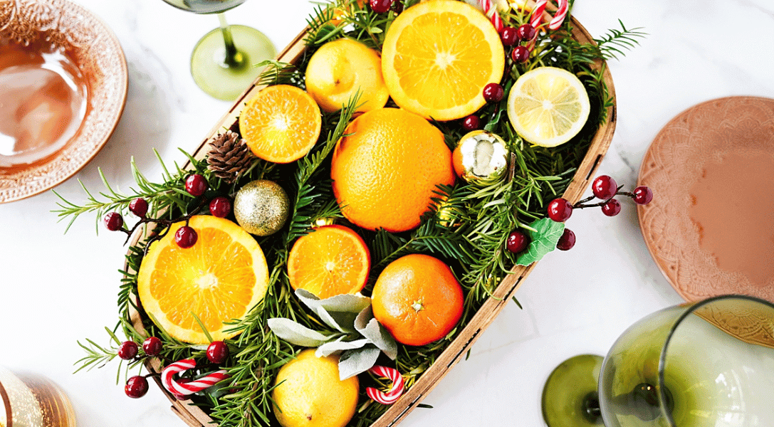 Citrus Centerpiece with Holiday decor of pine cones, cranberries, candy canes and mini oranmanets