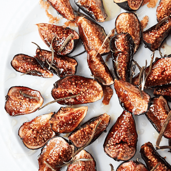 Close up of oven roasted figs on a white plate
