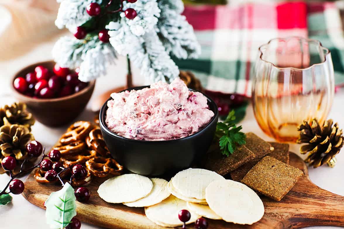 head on shot of christmas themed cranberry jalapeno dip on serving platter with pretzels and crackers