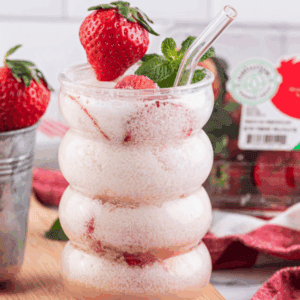 Strawberry Dirty Soda in glass surrounded by Naturipe strawberries