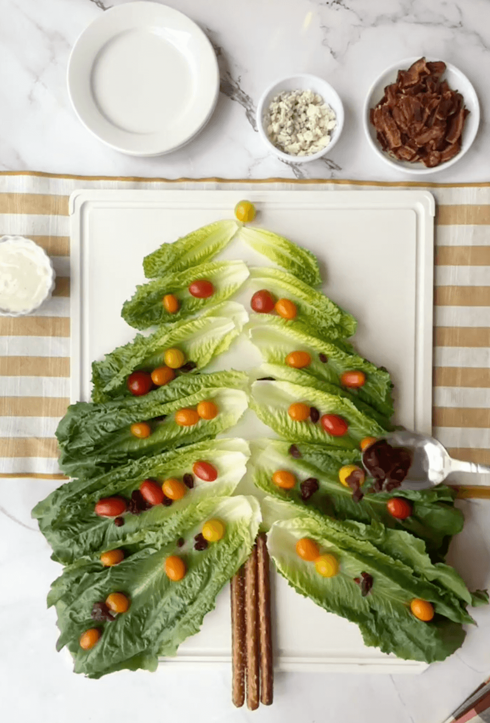 Layering the Christmas tree with the dried cranberreis and grape tomatoes