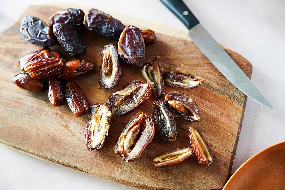 cut dates on a wood cutting board with knife
