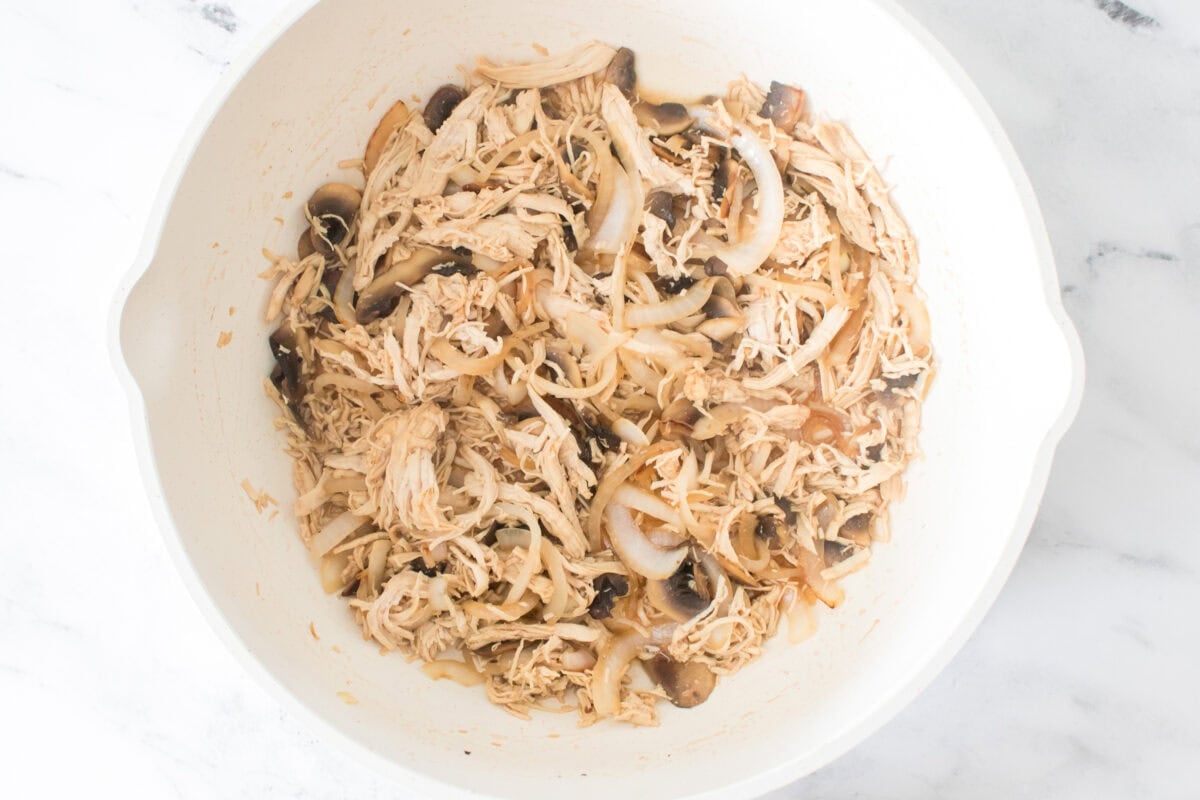overhead shot of oil, shredded chicken, sliced mushrooms, sliced onions and brown sugar soy sauce