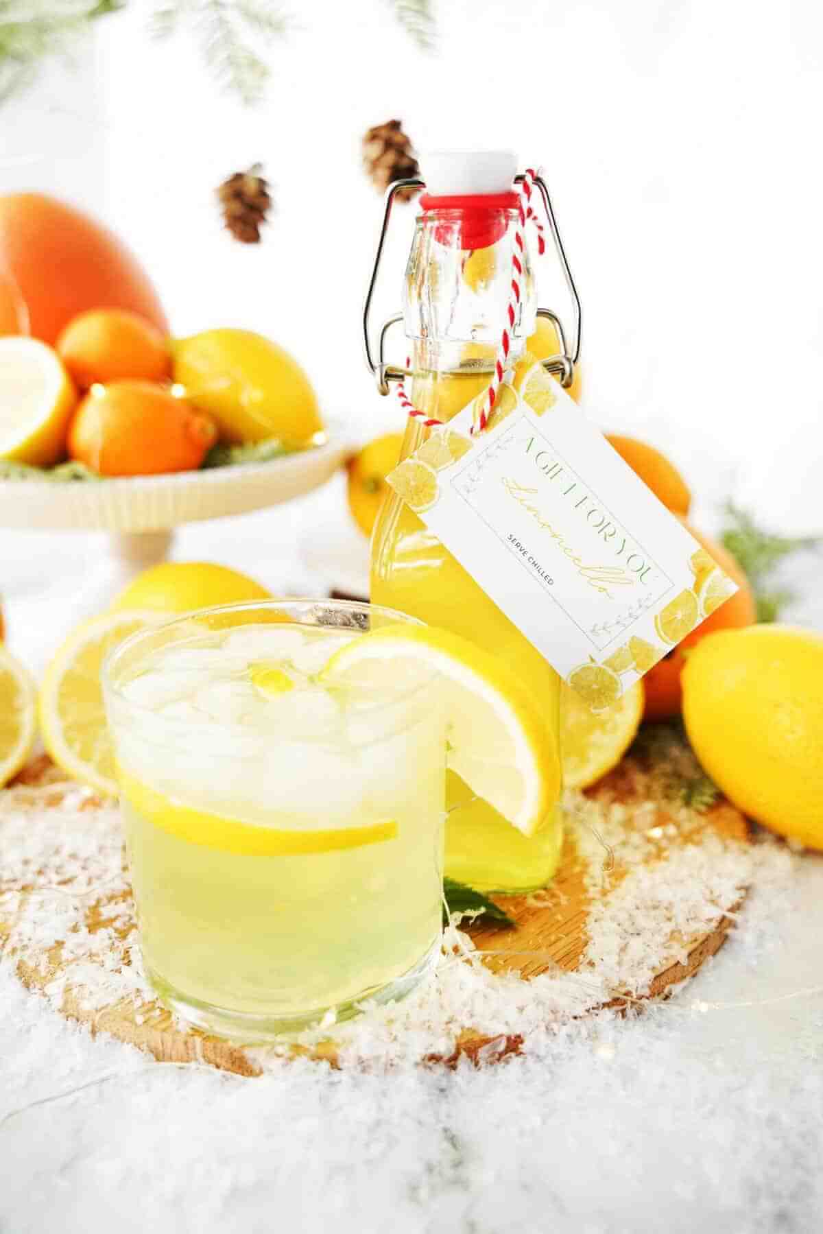 hommade limoncello in bottle and poured in a glass with wintery setting