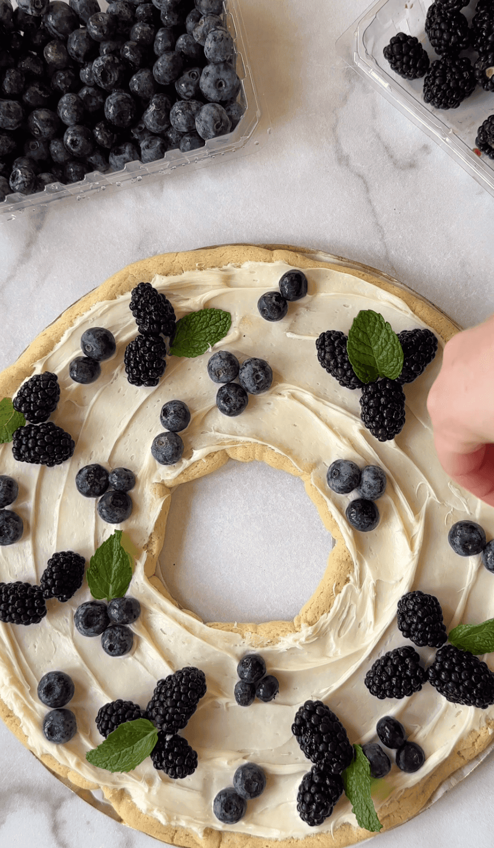 Adding mint to the berry cookie wreath