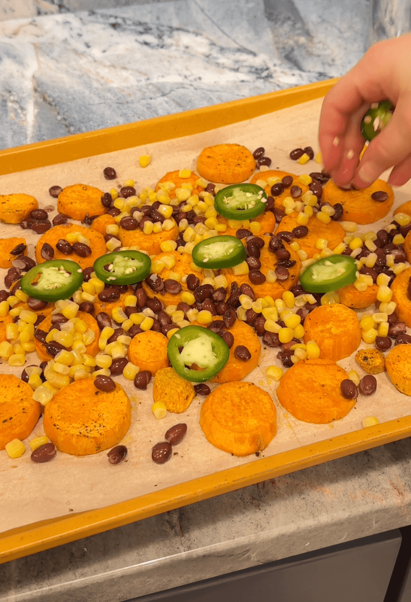 adding toppings on sheet pan over sweet potato rounds