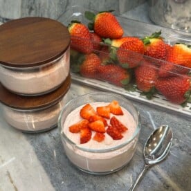 Blended Strawberry Overnight Oats in container with strawberries in background