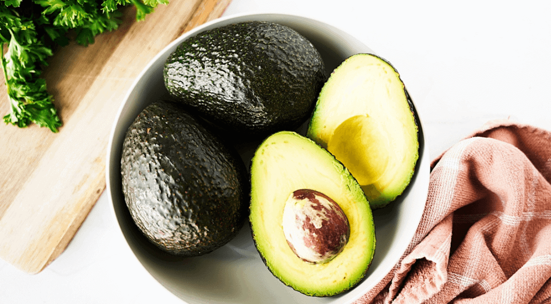 White bowl with avocados and one opened