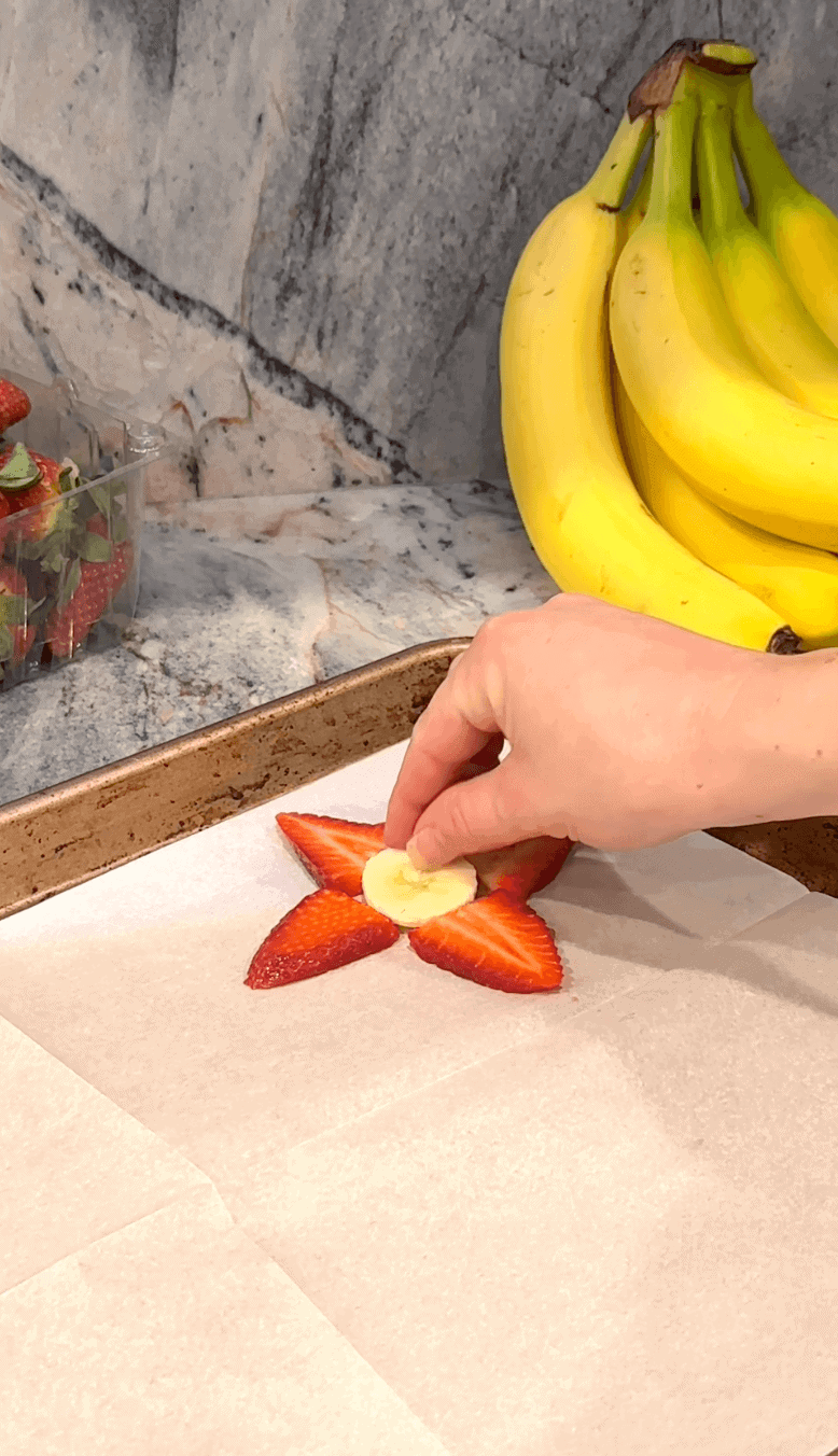 Laying out the strawberry and banana slices on baking sheet