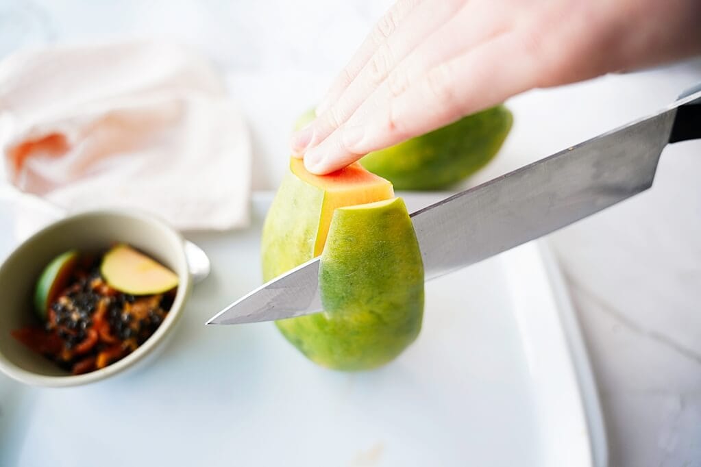 Taking the skin off a papaya with a knife