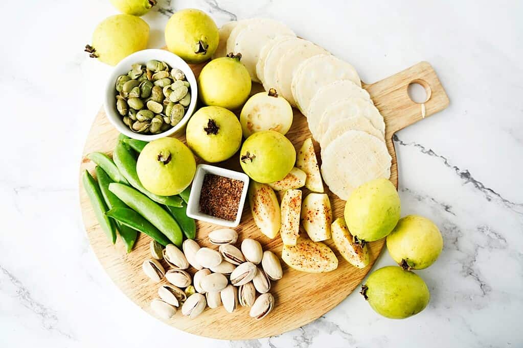 Charcuterie board with whole and cut guava slices and more