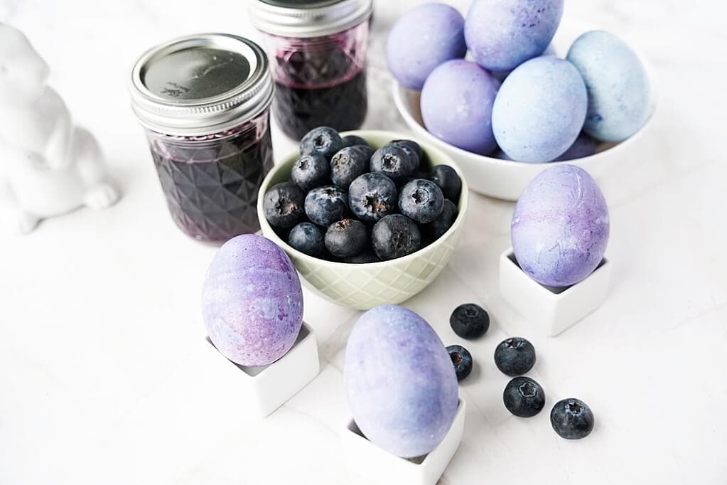 close-up of Blueberry-dyed hard boiled eggs with blueberries in a bowl