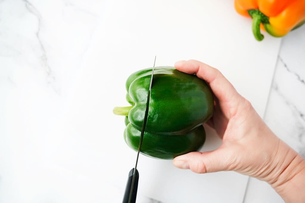 cutting the top of the green bell pepper