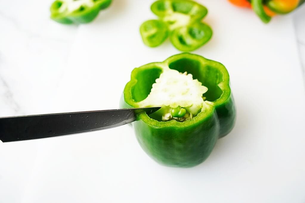 removing the seeds and pith of the green bell pepper