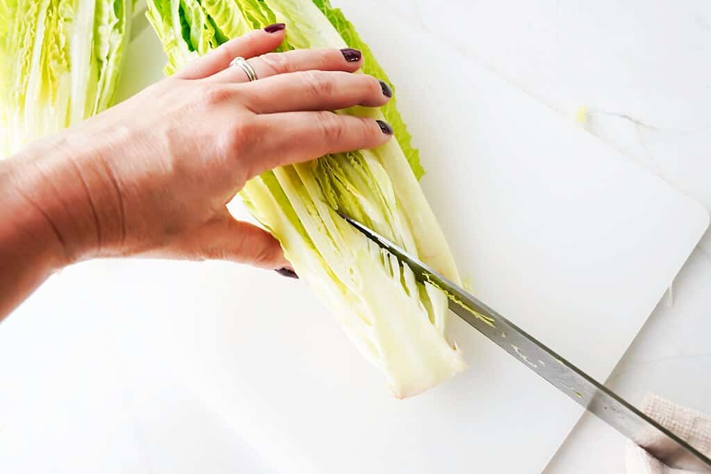 Step 2 in cutting romaine lettuce by removing the core