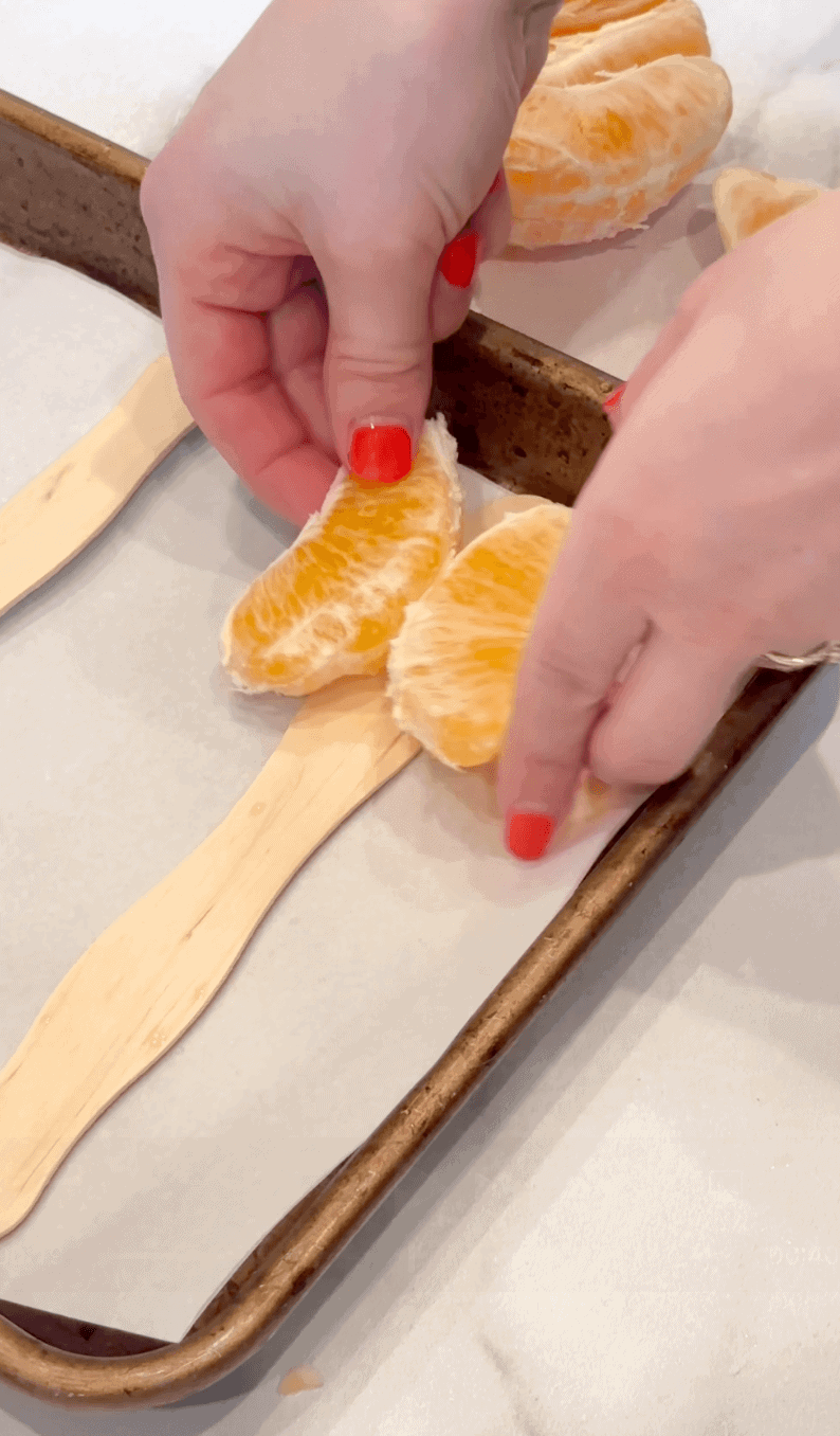 laying to mandarin pieces on popsicle stick