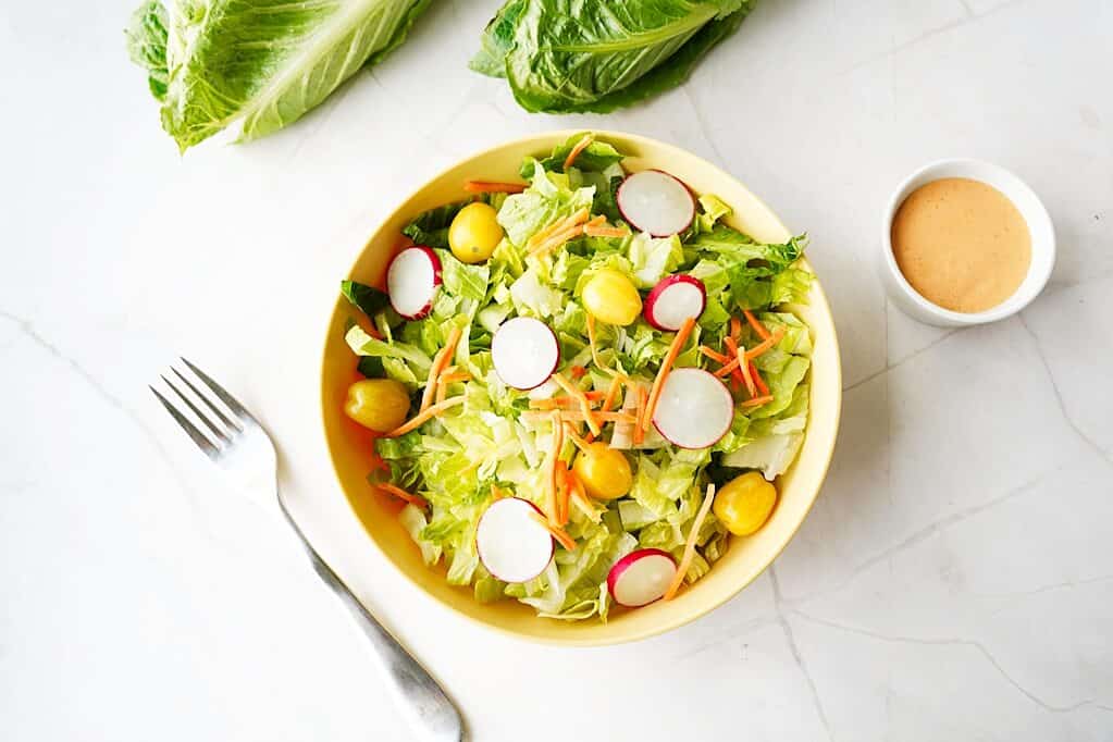 Overhead view of a salad with romaine lettuce and veggie toppings