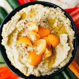Overhead shot of Golden Tomato Hummus in a bowl on a snack plate
