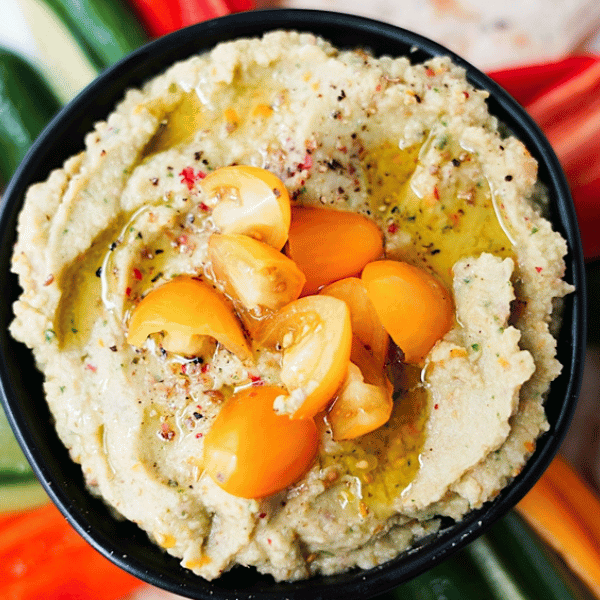 Overhead shot of Golden Tomato Hummus in a bowl on a snack plate