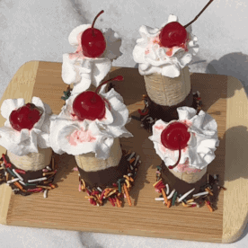 Overhead view of 5 banana split bites on a wooden board
