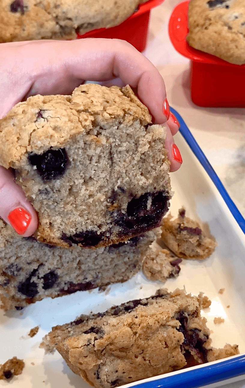 Squeezing a slice of the blueberry zucchini bread