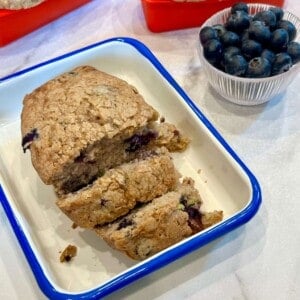 Vertical image of Blueberry Zucchini Bread in a dish cut into slices