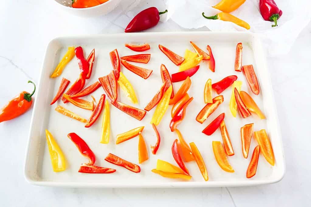 Strips of sweet mini peppers layed out on a sheet pan for a flash freeze