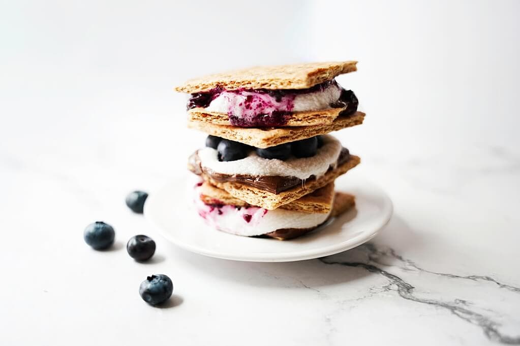Stack of Blueberry S'mores on a white plate on top of a counter