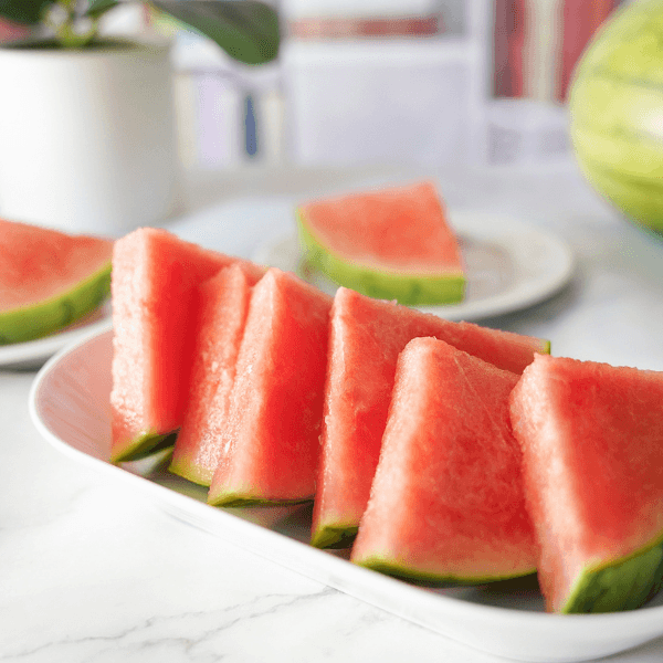 Slices of watermelon on white plate on countertop