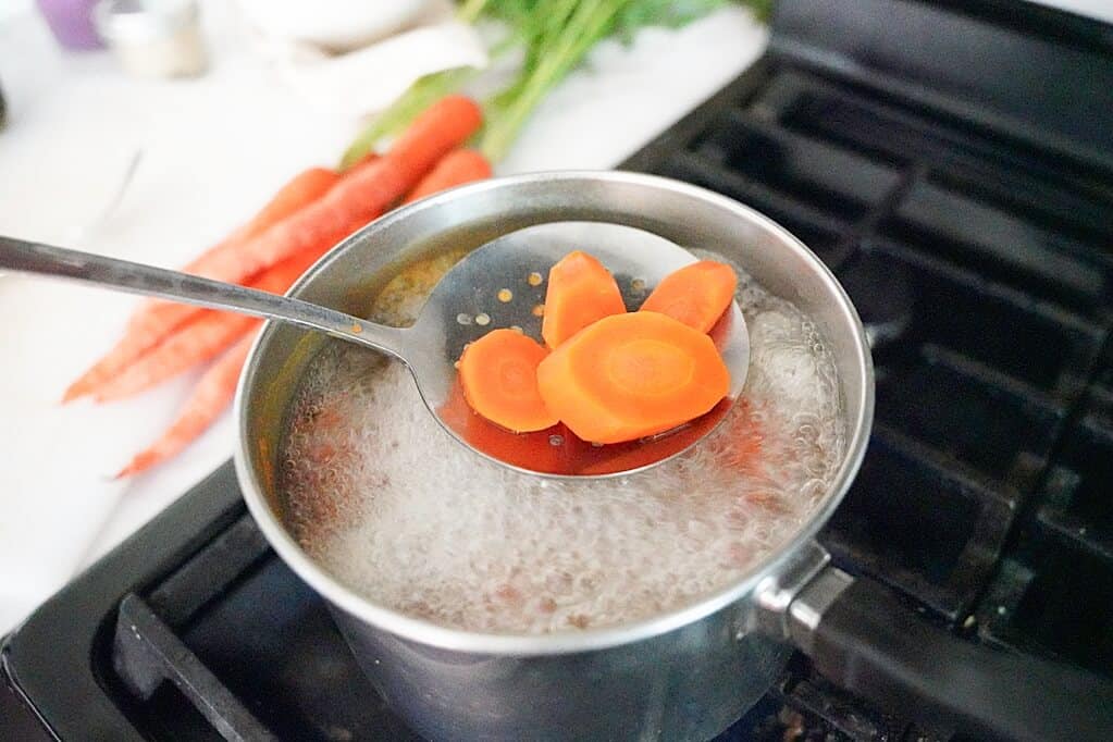 holding boiled carrots in spoon