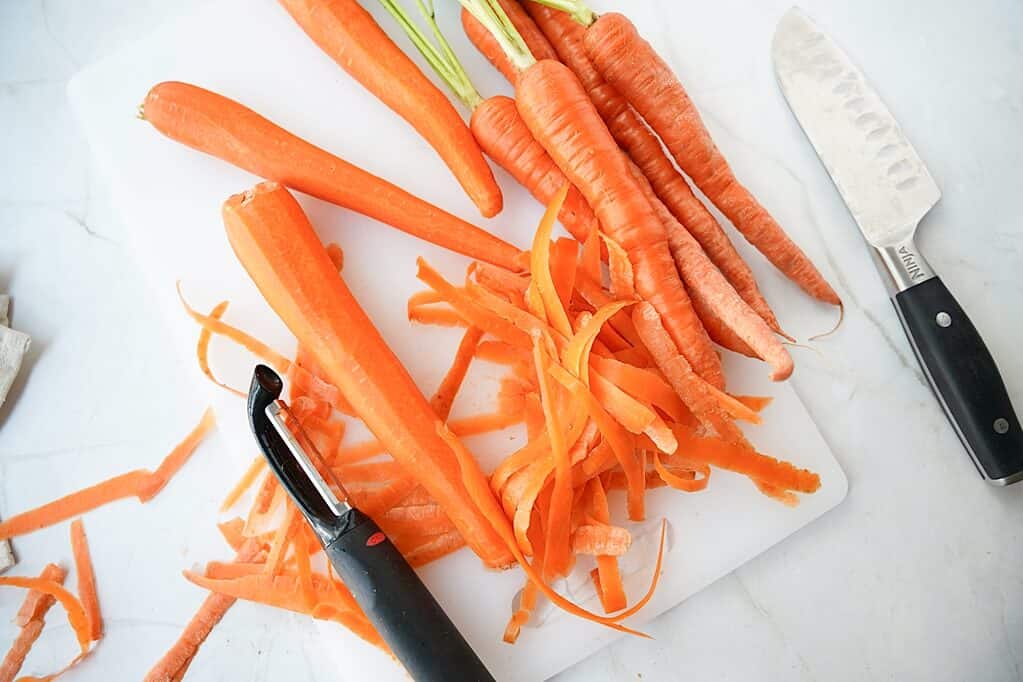 Peeling the carrots on a cutting board