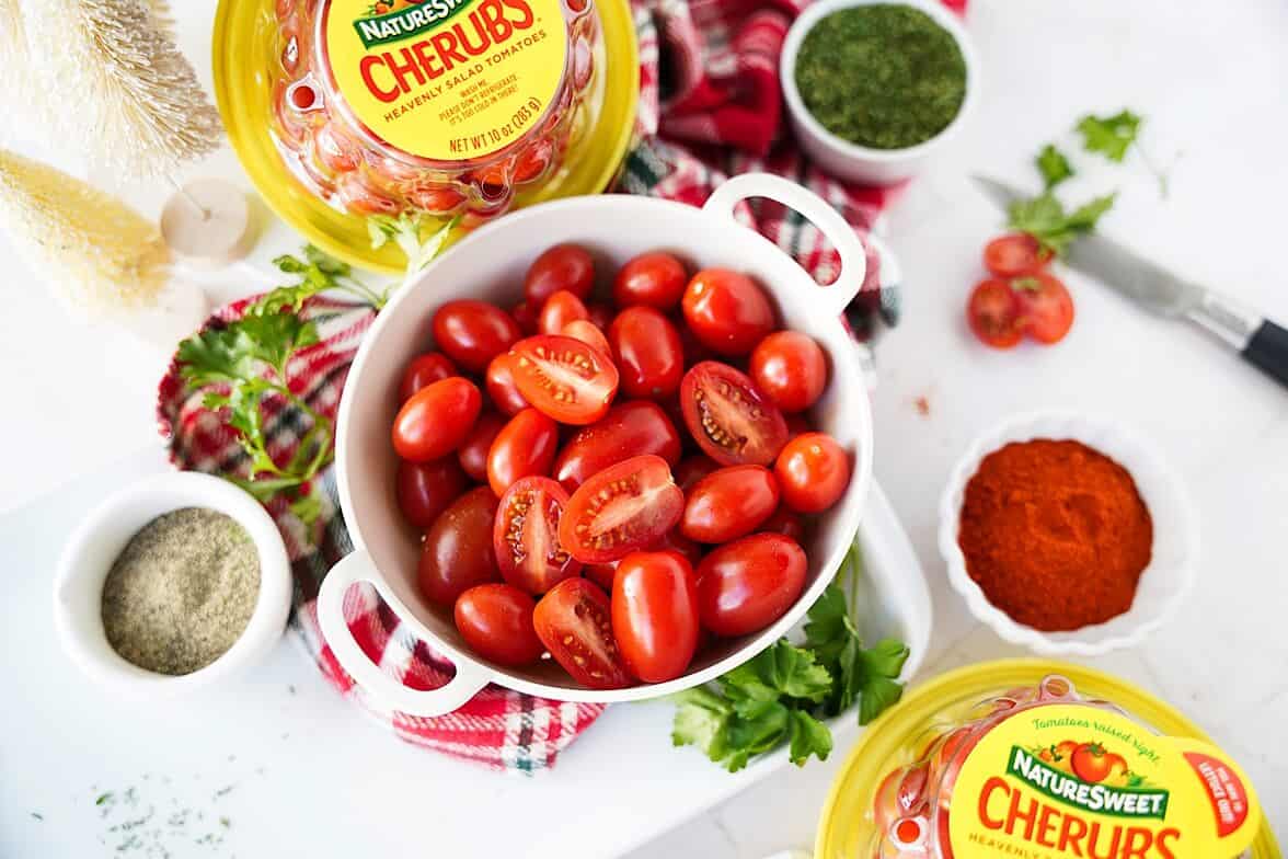 Grape tomatoes in a bowl surrounded by mini ramekins