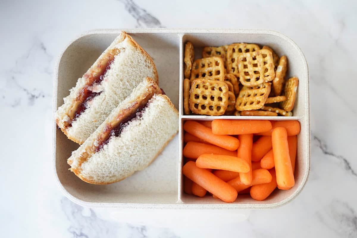 Bento lunch box with sandwich, pretzels, and baby carrots