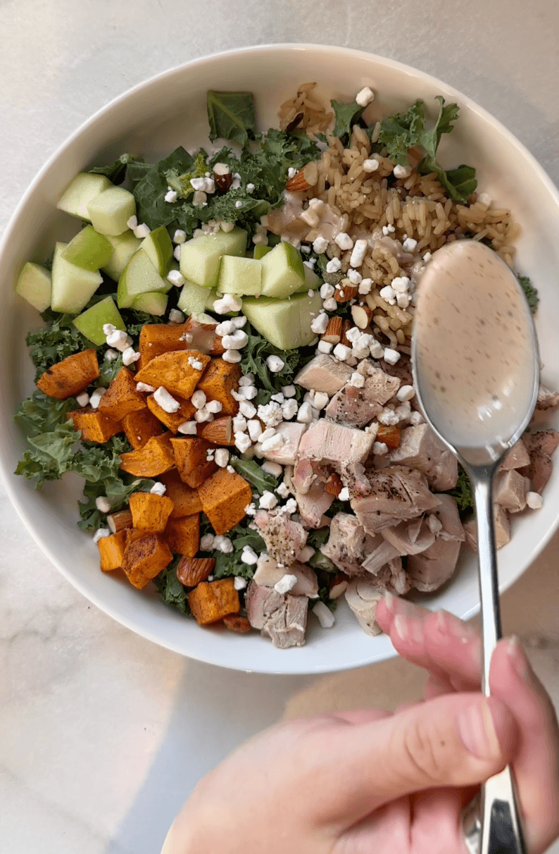 Drizzling dressing on Sweetgreen Harvest Salad