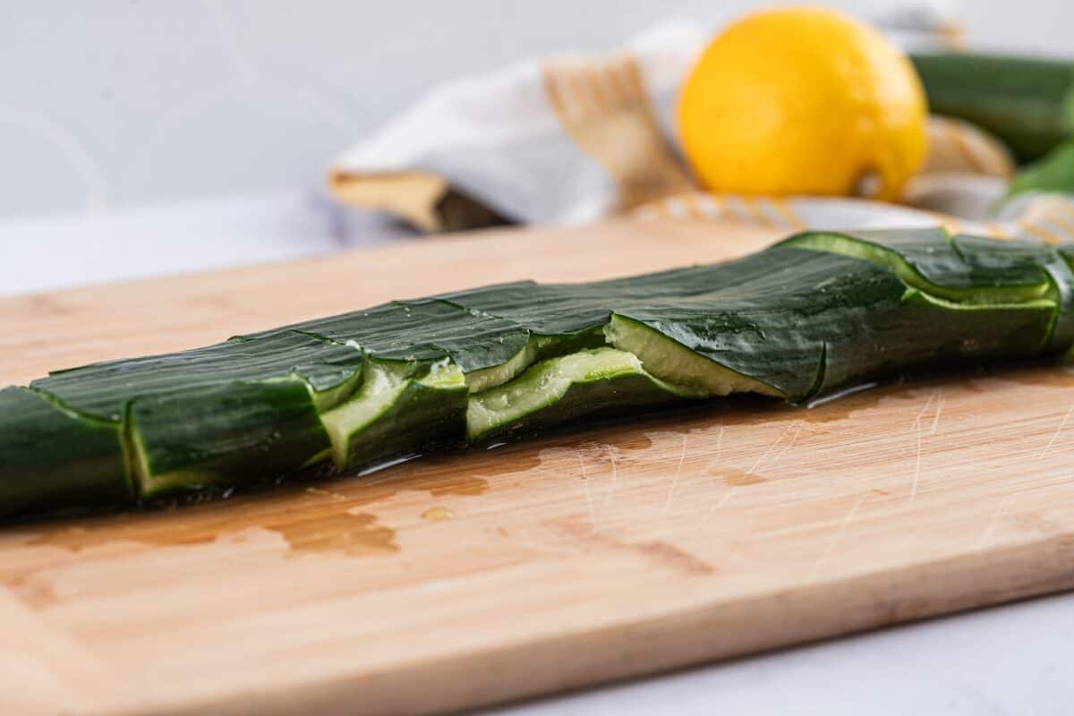 Crushed cucumber on a cutting board.