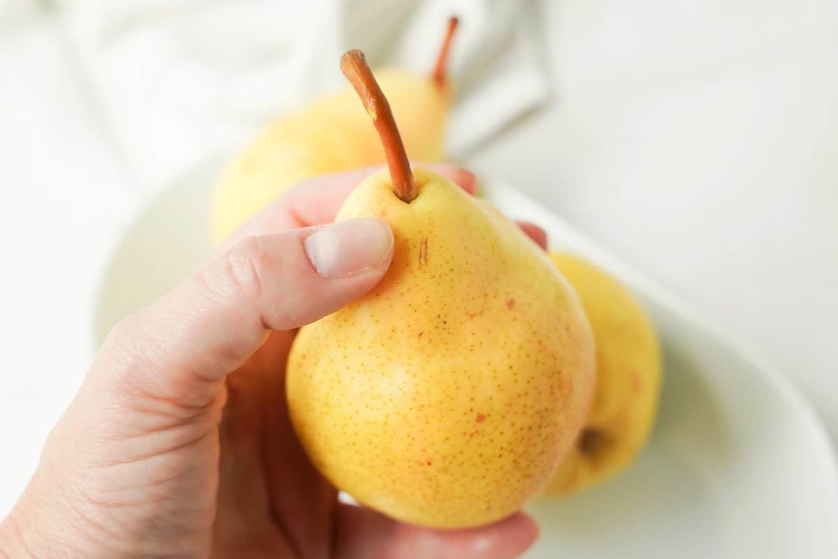 soft, deep yellow pears with spots in someone's hand