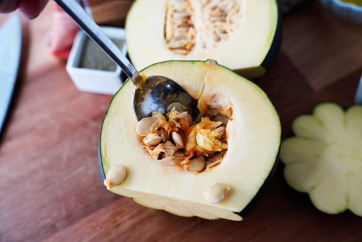 Scooping out seeds on havled acorn squash