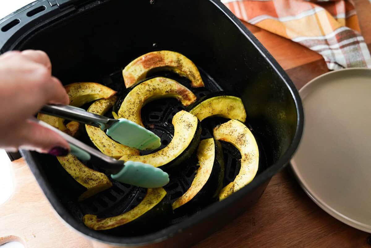 Flipping accorn squash pieces in air fryer basket