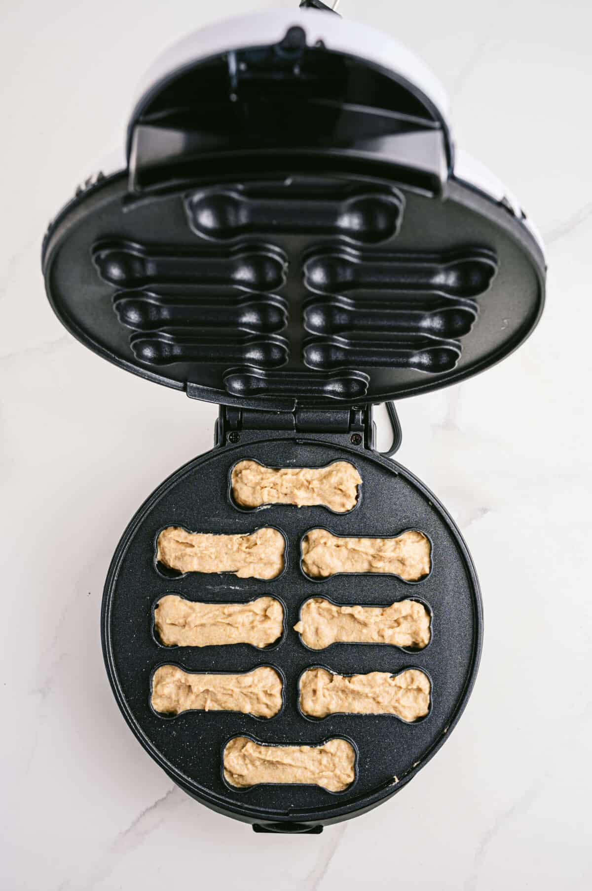apple & bacon dog treats in a treat maker before cooking