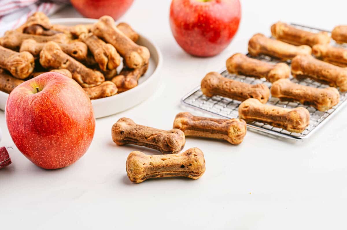 apple and bacon dog treats cooling on rack and on a plate with apples in the background