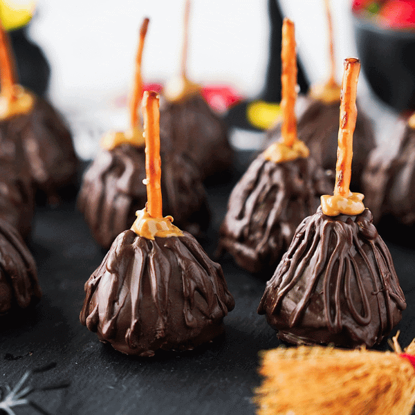 Close up of Strawberry Witch brooms on black platter with strawberries and brooms