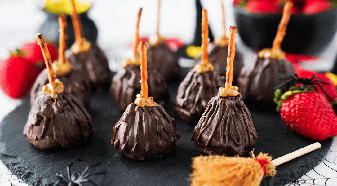 Close up of Strawberry Witch brooms on black platter with strawberries and brooms