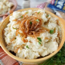 French onion mashed potatoes in a yellow serving bowl