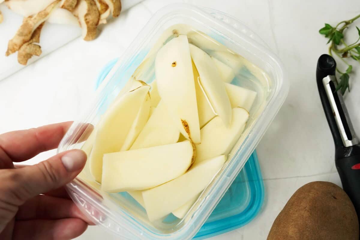 Soaking cut potatoe wedges in container